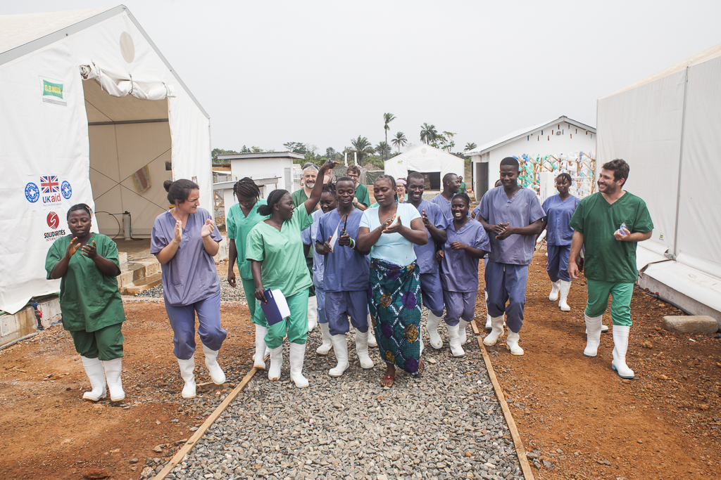 A moment of celebration during the discharge of Hawa Kargbo, the last Ebola survivor of Moyamba district. Hygienists and medical staff celebrate dancing and singing her recovery. At that time the number of new cases of Ebola in the country decreased significantly, and in Moyamba district went down almost to zero. It was a moment when the workers felt fully rewarded their exhausting efforts to defeat Ebola. Ebola Treatment Center. Moyamba. Sierra Leone.